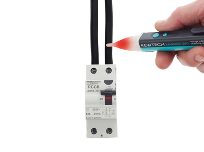 Electrician using a Kewtech Kewstick Duo non-contact voltage detector to identify live electrical cables